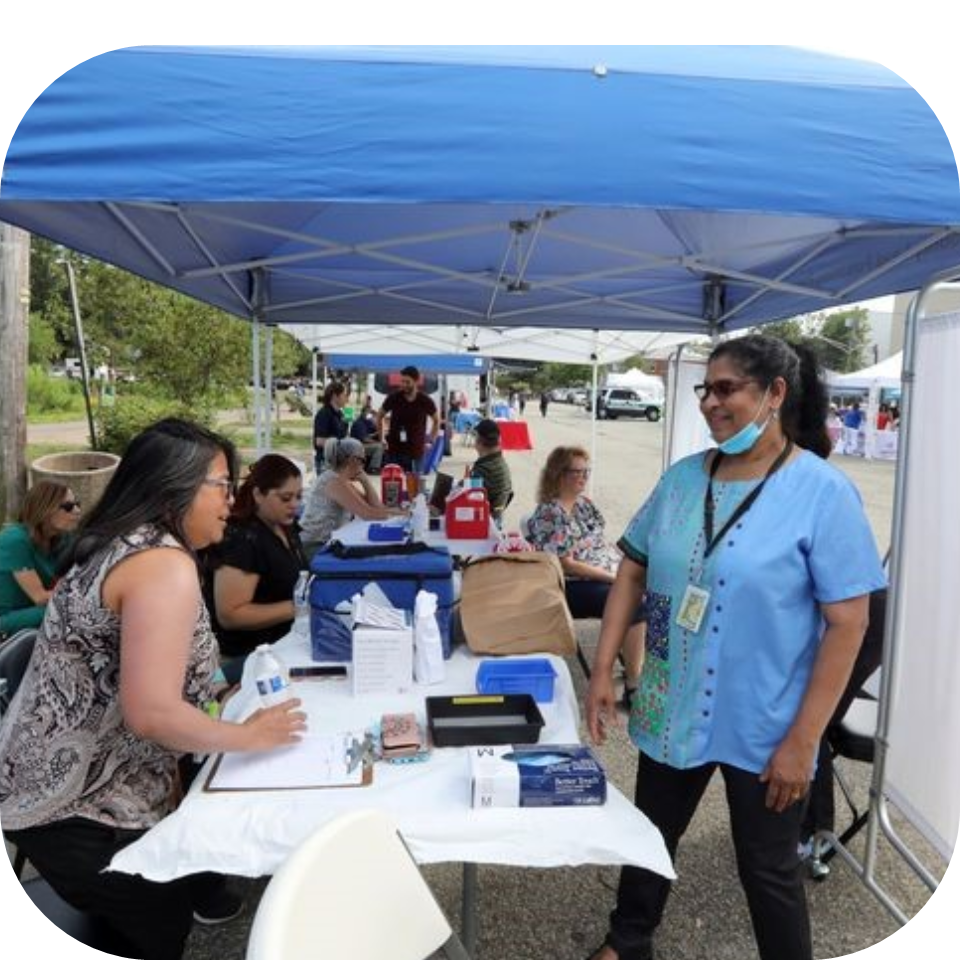 Cool Cube Clinic Nurses using a Cool Cube medical cooler at an outdoor vaccination clinic