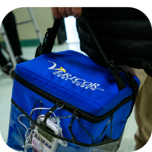 Man using a cool cube mobile medical cooler with a temperature monitor data logger in the front pocket to support cold chain transport