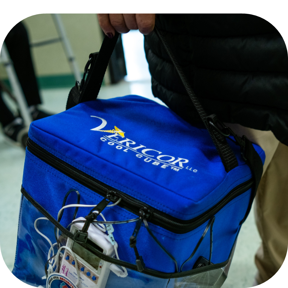 Man using a cool cube mobile medical cooler with a temperature monitor data logger in the front pocket to support cold chain transport